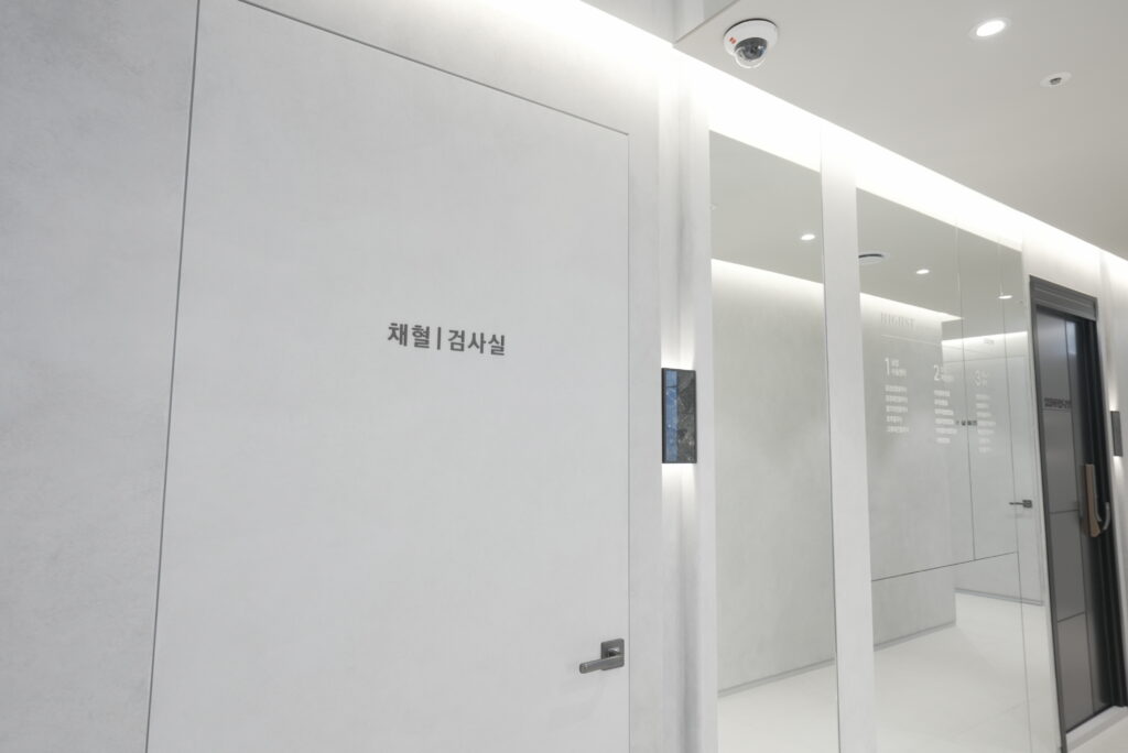 White corridor and room entrance at HIGHST Urology Clinic.