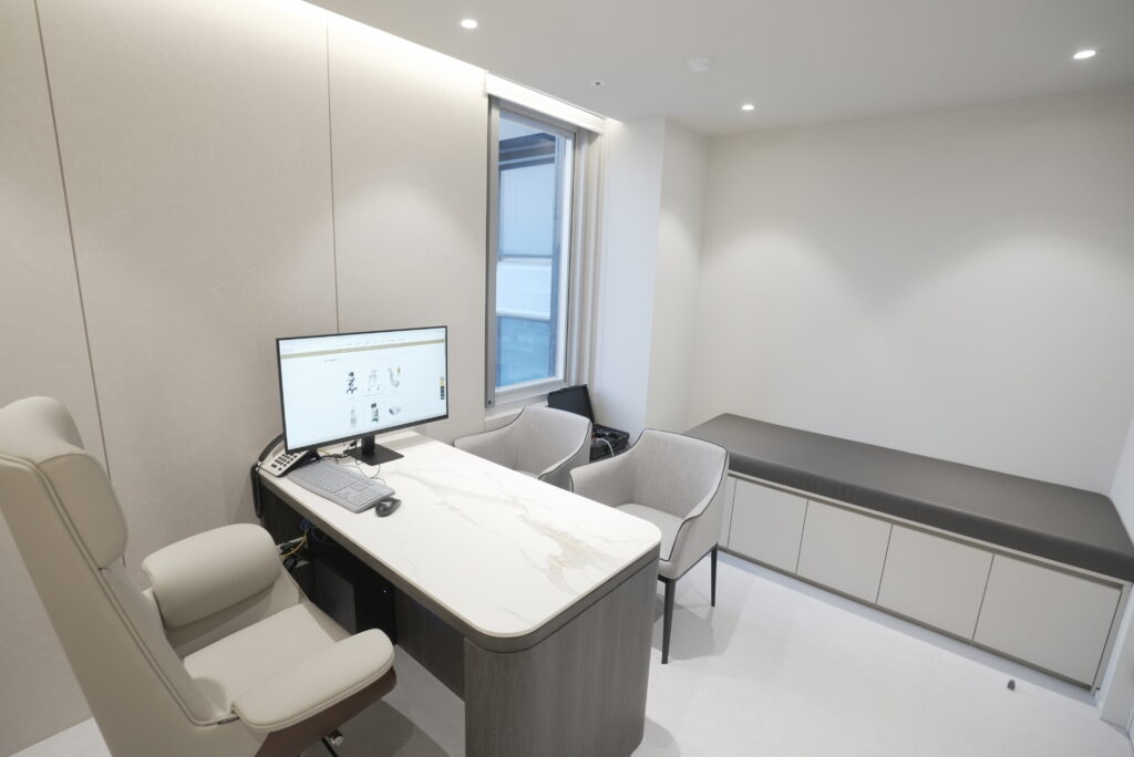 Consultation room with a desk, chairs and a bench at HIGHST Urology Clinic
